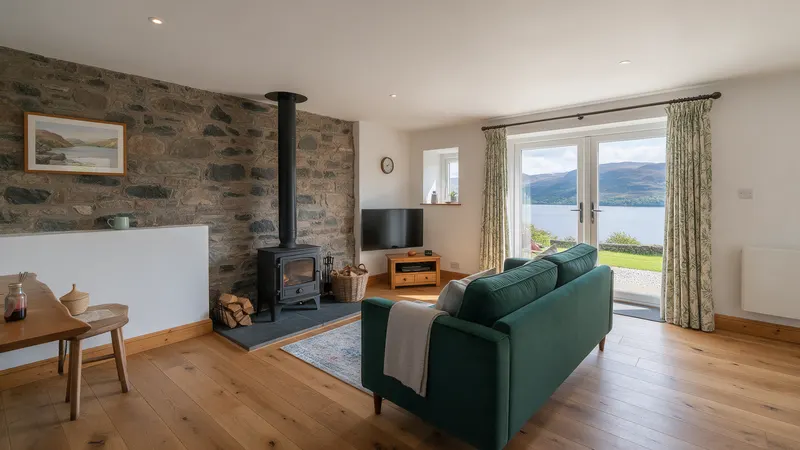Living room with stone wall, stove and view to the loch
